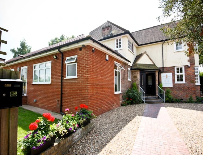 Exterior of Mona Lisa Smiles dental practice at 83 Station Rd, New Barnet EN5 1PX, with front garden and entrance path