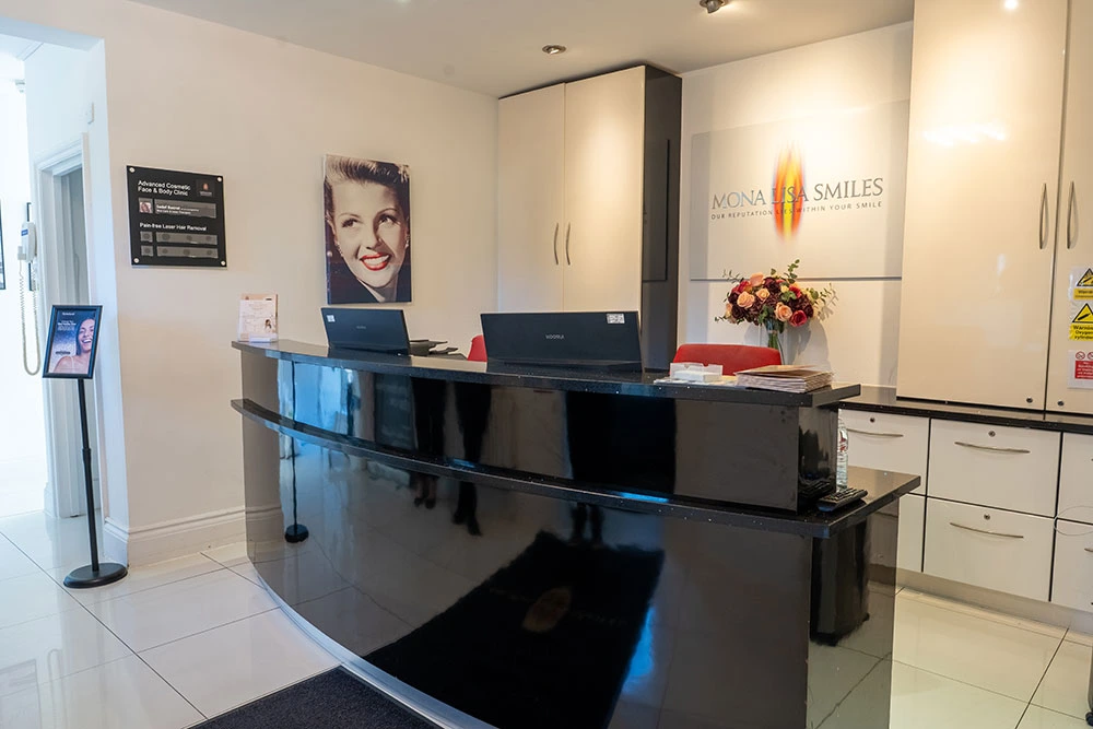 Reception desk and Mona Lisa Smiles logo inside the private dental practice in New Barnet, Barnet